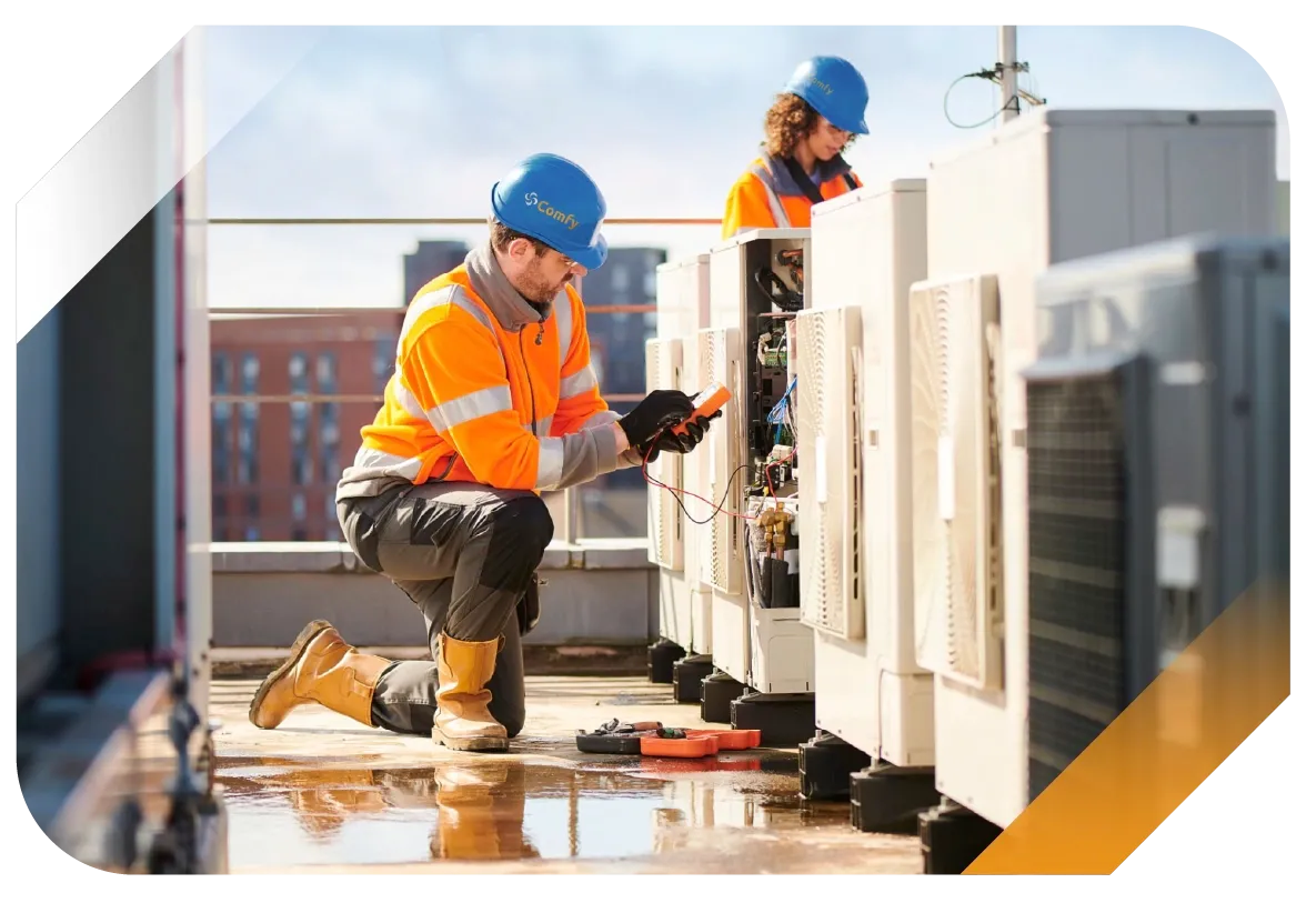 Two HVAC technicians diagnosing a commercial rooftop HVAC unit