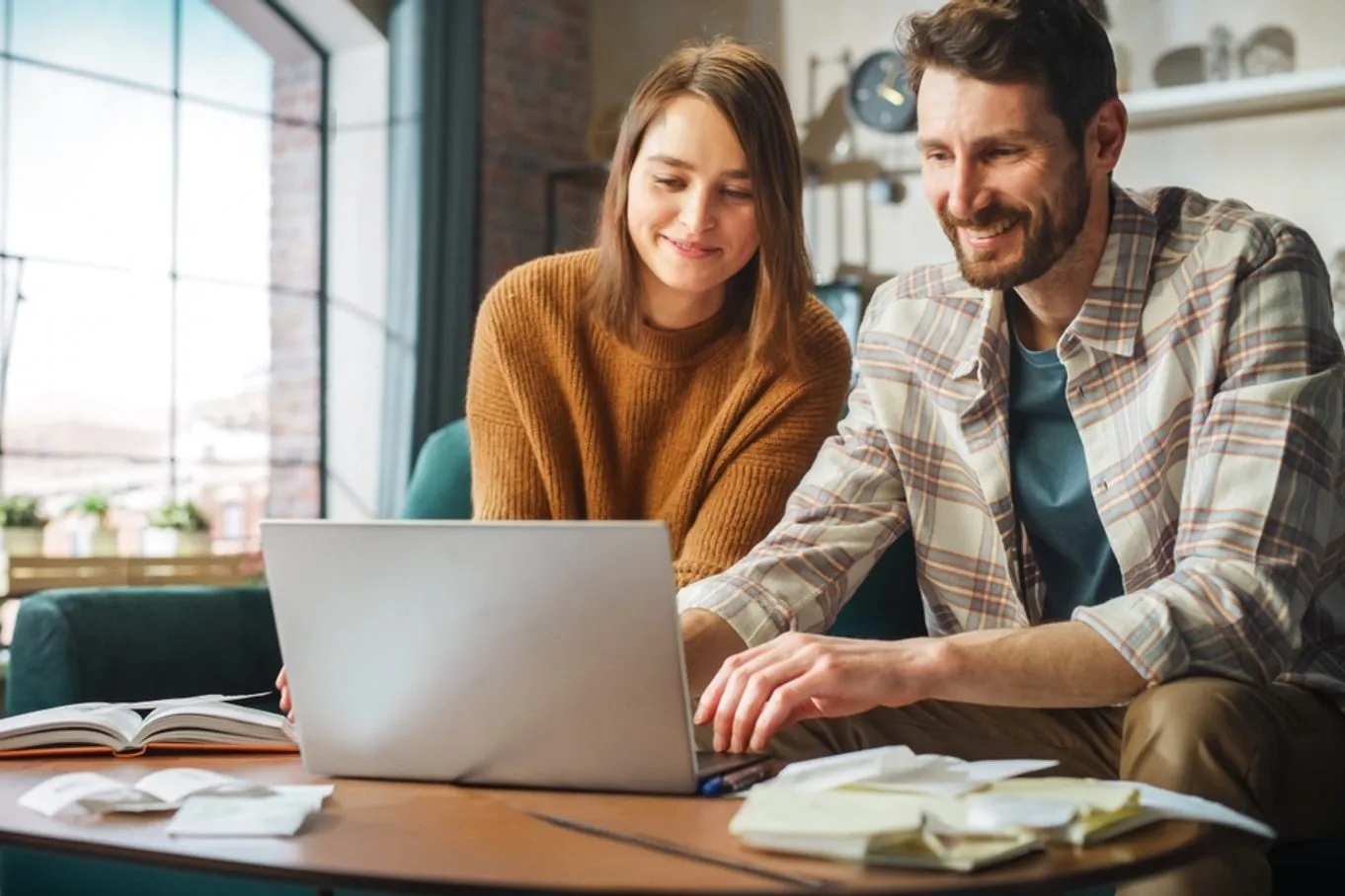 A couple submitting an online HVAC financing application on a laptop